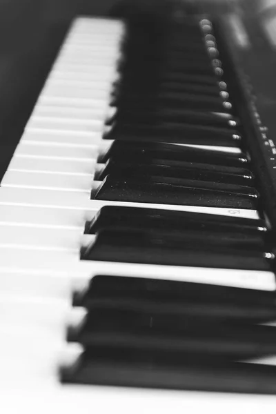 Tasti per pianoforte in bianco e nero, vista laterale. Il concetto di musica . — Foto Stock