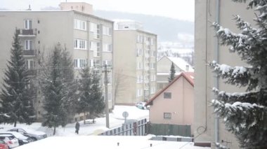 Kış şehirde, sokak, düz evler, ağaçlar ve arabalar Karlar, patika üzerinde bazı walker gider.