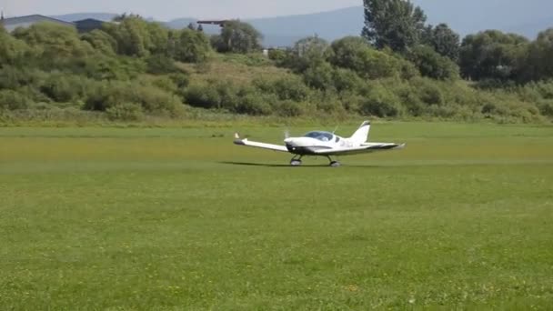 Pesawat berbaling-baling putih berpenggerak baling-baling ganda PS-28 Cruiser lepas landas di lapangan terbang rumput di bandara negara ini — Stok Video