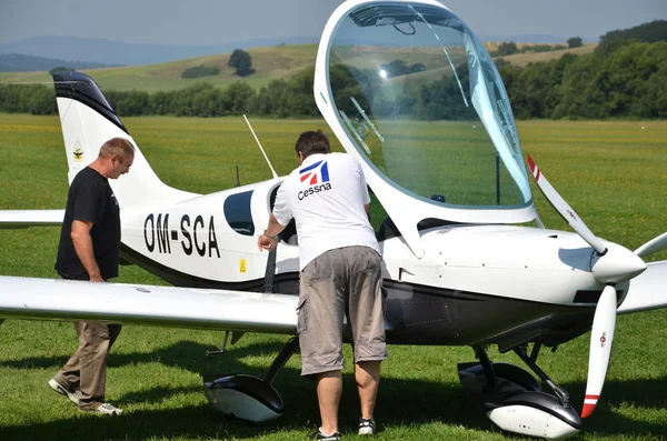 Männer checken das kleine Privatflugzeug vor dem Start und bereiten sich neben der Landebahn auf den Flug vor — Stockfoto