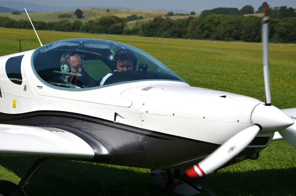 Zwei Männer sitzen in einem ultraleichten Propellerflugzeug und bereiten sich auf den Start vor — Stockfoto