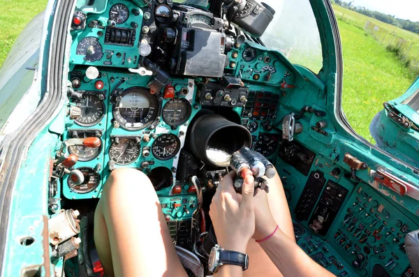Mädchen sitzt in der Kabine eines alten Kampfjets Mig-21 und hält den Steuerknüppel in der Hand, Blick auf die Steuerung — Stockfoto