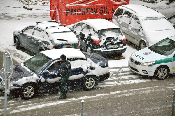 O trânsito da polícia parou um carro. Policial ficar fora do veículo em mau tempo e conversar com o motorista enquanto a neve cai . — Fotografia de Stock