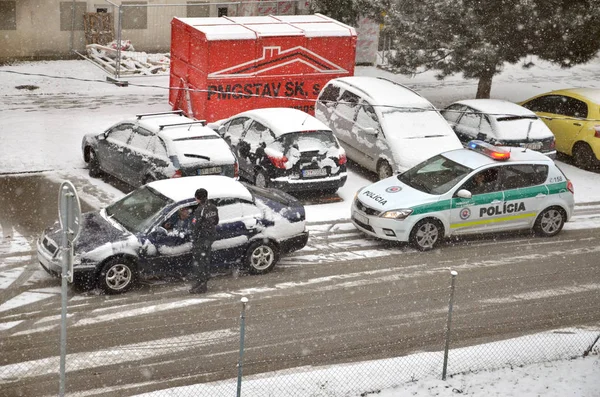 Police traffic partol stop a car. Policeman stand outside vehicle in bad weather and talk with driver while snow falls. — Stock Photo, Image