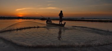 Mandalay. Myanmar. 21 Kasım 2016. Her sabah yerel balıkçıların ağları üzerinden bir teknede Gölü Taungthaman ile balık yakalamak.