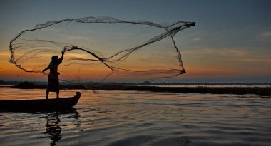 Mandalay. Myanmar. 21 Kasım 2016. Her sabah yerel balıkçıların ağları üzerinden bir teknede Gölü Taungthaman ile balık yakalamak.
