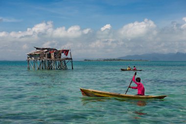 Doğu Malezya. Borneo adası. 2018 / 11 / 29. Tahta teknelerle bir balıkçı köyünden gelen çingeneler tahta ayaklıklar üzerine inşa edilmiş kulübelerin arasında hareket ederler..