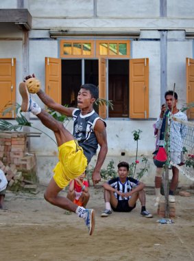 Mandalay, Myanmar. 24 Kasım 2016. Gençler, genç bambu sapından yapılmış ev yapımı özel bir topla sokakta Malay voleybolu (sepaktakrau) oynuyor. Bu spor Asya ülkelerinde çok yaygındır..