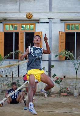 Mandalay, Myanmar. 24 Kasım 2016. Gençler, genç bambu sapından yapılmış ev yapımı özel bir topla sokakta Malay voleybolu (sepaktakrau) oynuyor. Bu spor Asya ülkelerinde çok yaygındır..