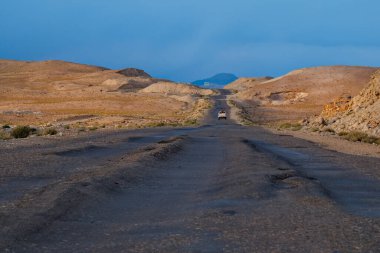Cezayir, Tacikistan 'dan. 10 Ağustos 2019. Kamyonet, 40 derecenin üzerindeki dayanılmaz sıcaklıktan dolayı asfaltın eridiği Pamir otoyolu boyunca yavaşça ilerliyor.