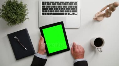 Bir adamın bir i-Pad ile yeşil bir ekran Holding eller