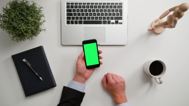 Manos de hombre sosteniendo un teléfono con una pantalla verde — Vídeo de stock