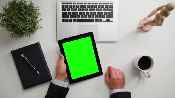 Manos de hombre sosteniendo un i-Pad con una pantalla verde — Vídeos de Stock