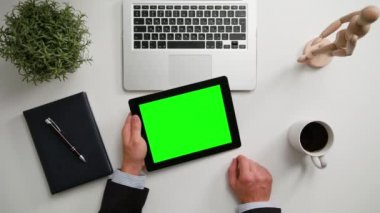 Bir adamın bir i-Pad ile yeşil bir ekran Holding eller