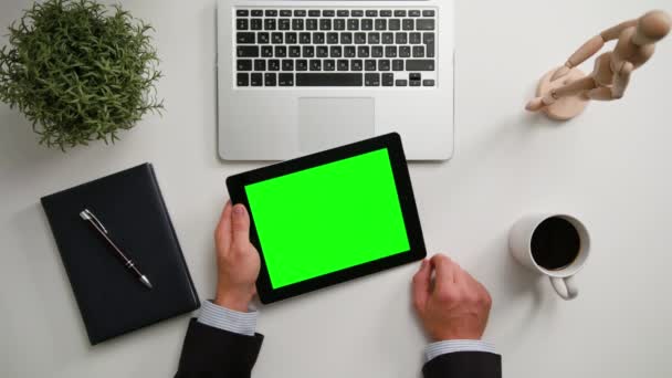 Manos de hombre sosteniendo un i-Pad con una pantalla verde — Vídeos de Stock