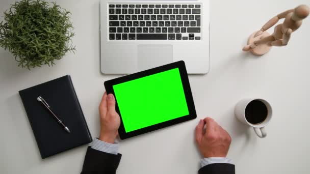 Manos de hombre sosteniendo un i-Pad con una pantalla verde — Vídeos de Stock