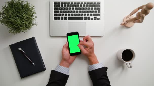 Manos de hombre sosteniendo un teléfono con una pantalla verde — Vídeos de Stock