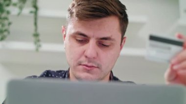 Kapalı bir dizüstü bilgisayar kullanarak bir genç adam