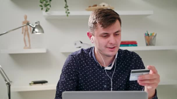 Молодой человек с ноутбуком в помещении — стоковое видео