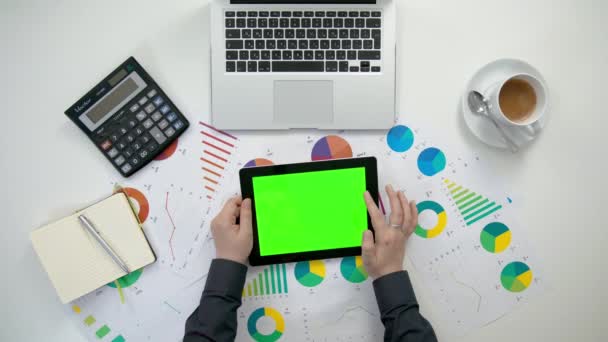 Manos de hombre sosteniendo un i-Pad con una pantalla verde — Vídeos de Stock