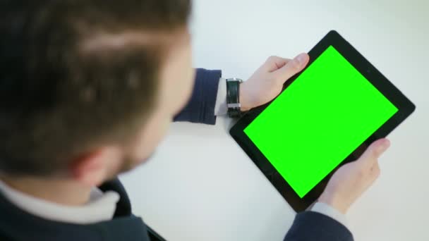 Un hombre usando un iPad con una pantalla verde — Vídeo de stock