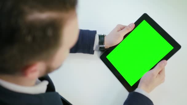 Α ο άνθρωπος χρησιμοποιώντας ένα ipad με μια πράσινη οθόνη — Αρχείο Βίντεο