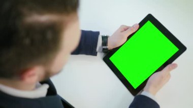 Bir adam kullanarak bir ipad ile yeşil perde