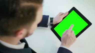 Bir adam kullanarak bir ipad ile yeşil perde
