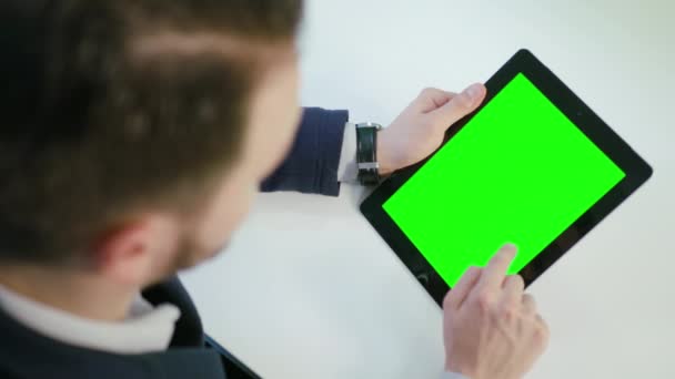 Un hombre usando un iPad con una pantalla verde — Vídeo de stock