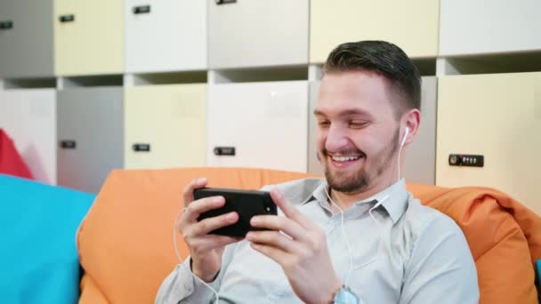 Man Watching Videos on the Smartphone Indoors — Stock Video