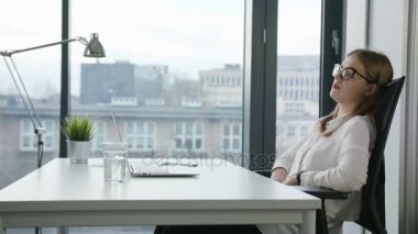 Oturma ve kapalı bir dizüstü bilgisayar kullanarak Bisinesswoman