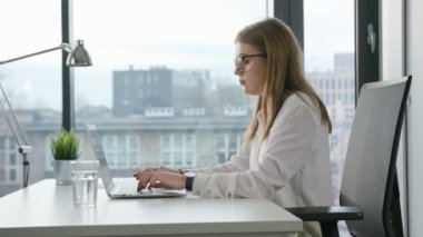 Oturma ve kapalı bir dizüstü bilgisayar kullanarak Bisinesswoman