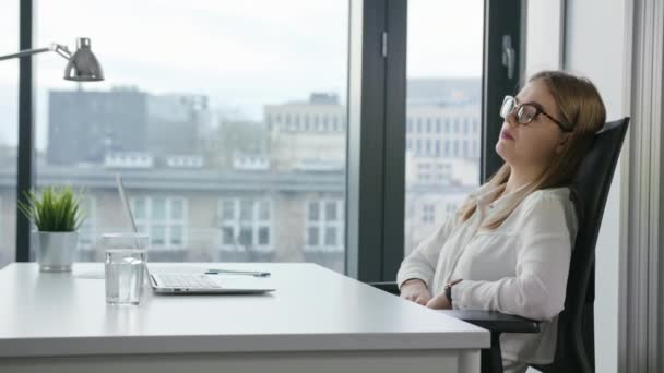 Bisinesswoman sentada y usando una computadora portátil en interiores — Vídeos de Stock