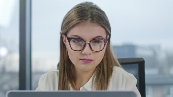 戴眼镜的年轻女士看着笔记本电脑 — 图库视频影像