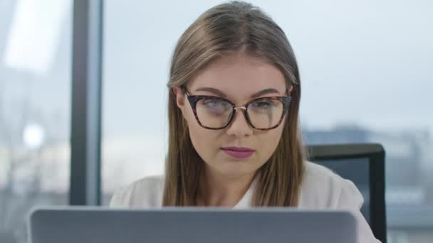 Ung dam med glasögon tittar på den bärbara datorn — Stockvideo