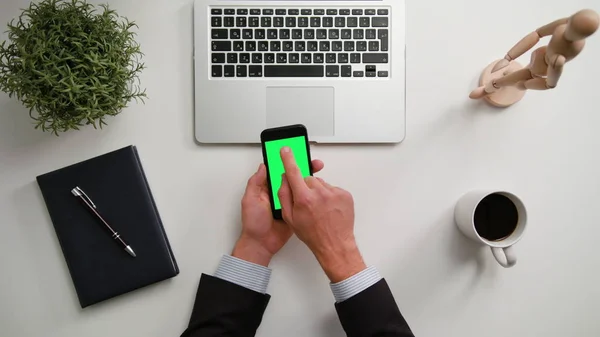 A Mans yeşil bir ekran ile bir telefon Holding eller