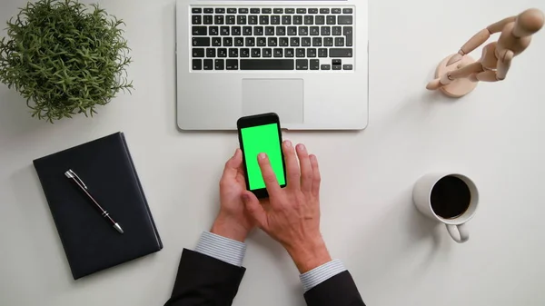 Чоловік тримає телефон із зеленим екраном — стокове фото