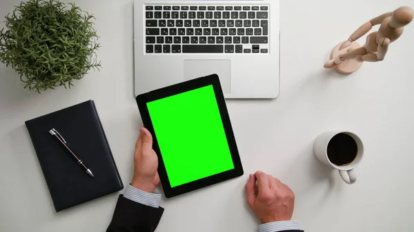 Bir adamın bir i-Pad ile yeşil bir ekran Holding eller