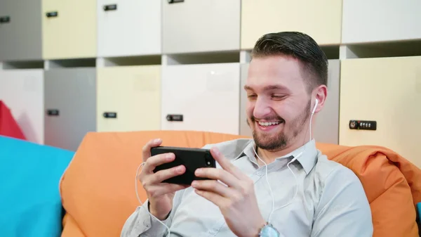 Человек смотрит видео на смартфоне в помещении — стоковое фото
