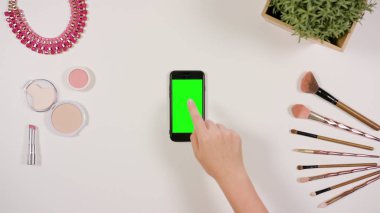 Bir Smartphone ile yeşil bir ekran dokunaklı bir parmak