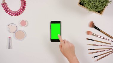 Bir Smartphone ile yeşil bir ekran dokunaklı bir parmak