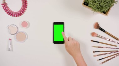 Bir Smartphone ile yeşil bir ekran dokunaklı bir parmak