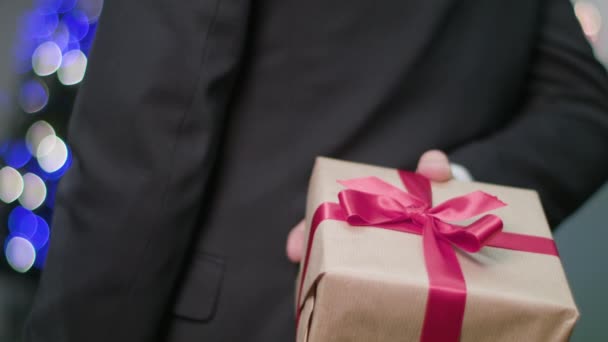 Чоловік тримає і дарує різдвяний подарунок — стокове відео
