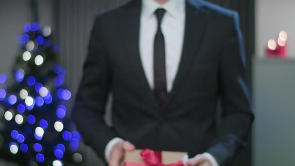 Männer halten ein Weihnachtsgeschenk in den Händen — Stockvideo