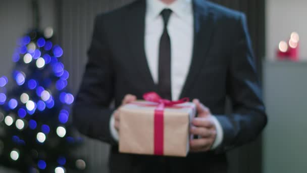 Männer halten ein Weihnachtsgeschenk in den Händen — Stockvideo