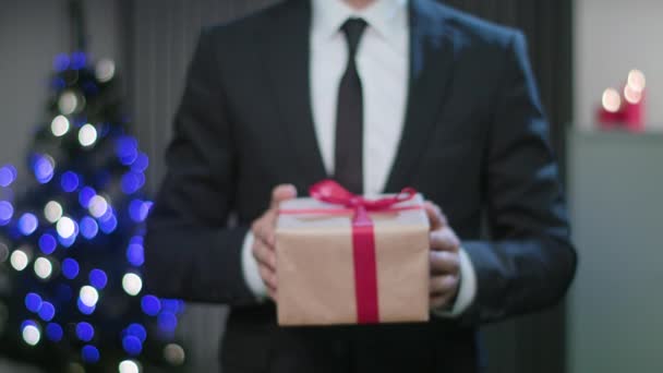 Επανδρώνει τα χέρια κρατώντας ένα χριστουγεννιάτικο δώρο — Αρχείο Βίντεο