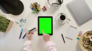 Bir Tablet dokunmaktan ve bir kredi kartı tutan eller