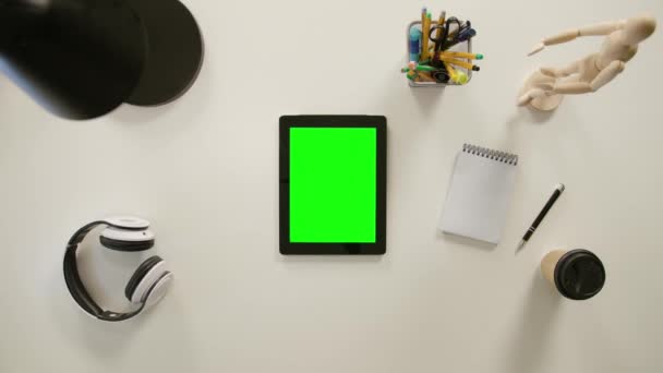 Un doigt touchant un écran vert de l'iPad 