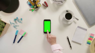 Bir Smartphone ile yeşil bir ekran dokunaklı bir parmak