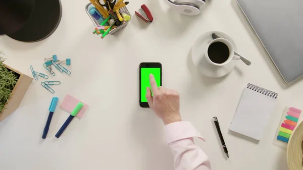 Пальцем, торкаючись смартфон з зеленим екраном — стокове фото
